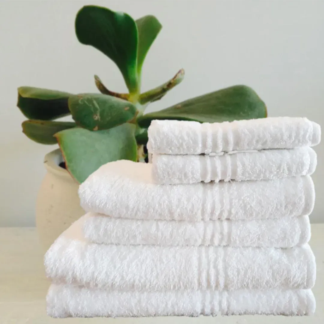 Stack of clean, white towels, one rolled on top.