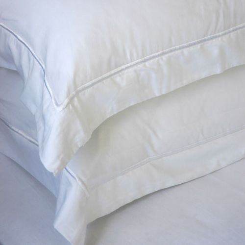 White pillowcases stacked, with a subtle border detail.
