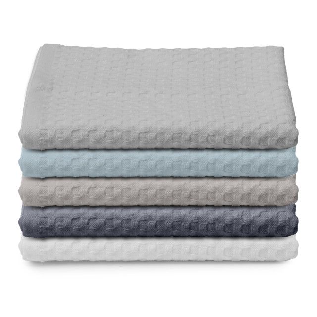 Stack of clean, white towels, one rolled on top.