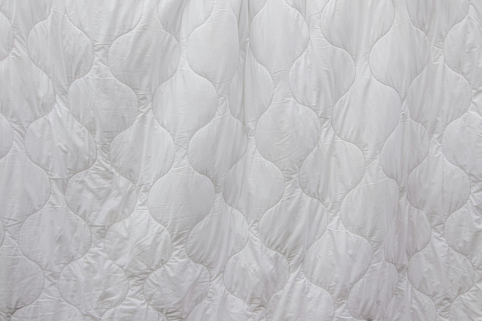 White quilted mattress with a stitched, oval-like pattern.