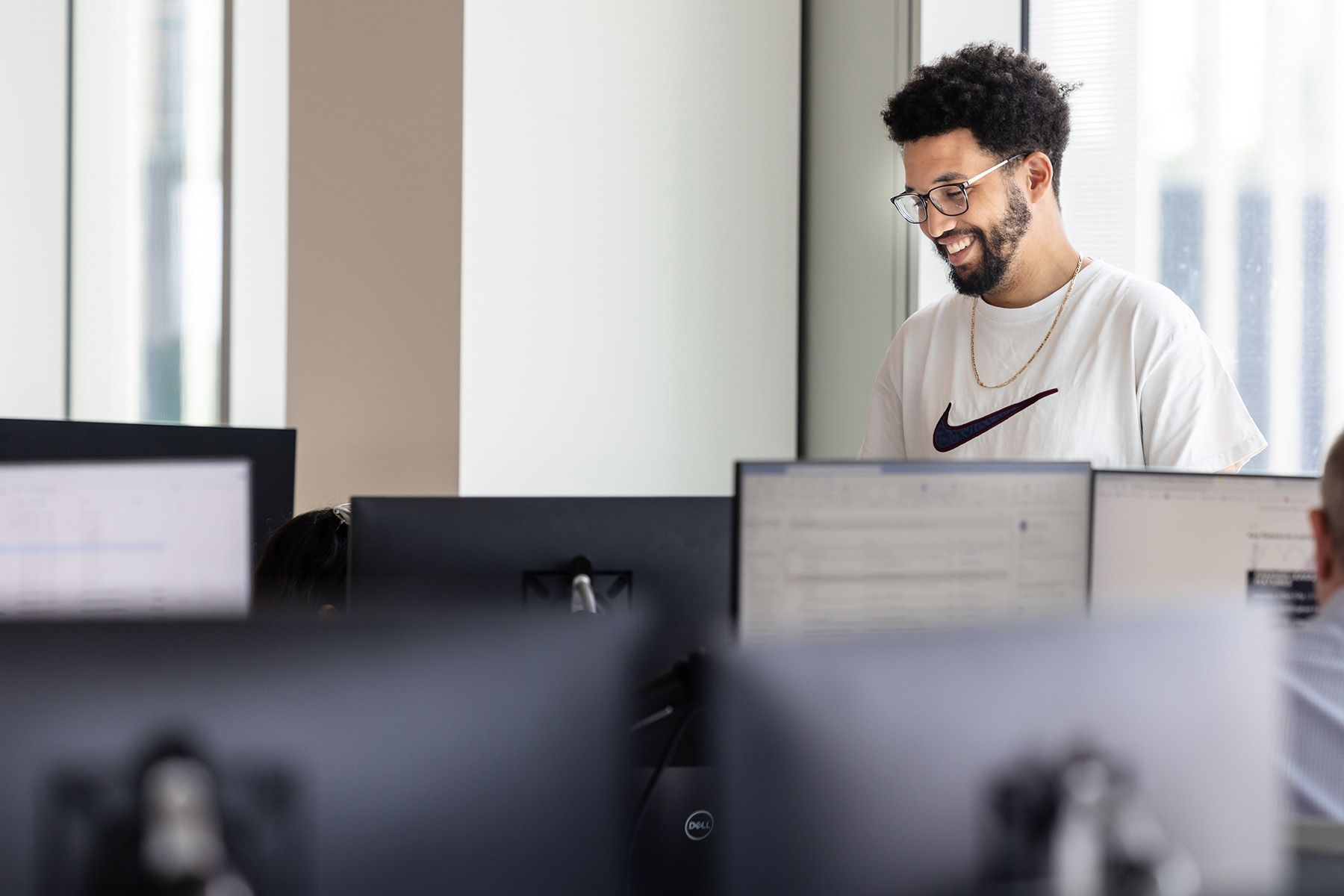 Commercial photographer Berkshire, bespectacled man working in an office chatting to colleague