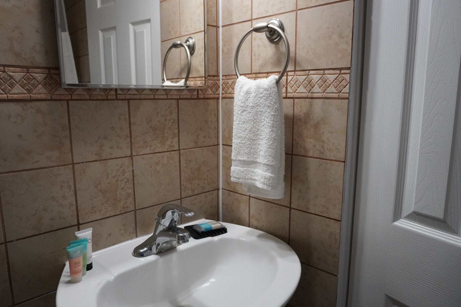 A bathroom with a sink a mirror and a towel hanging on the wall