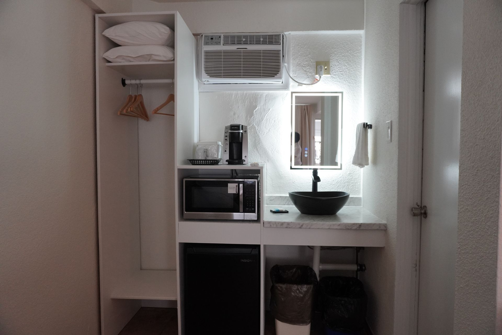 A small kitchen with a sink a microwave and a refrigerator