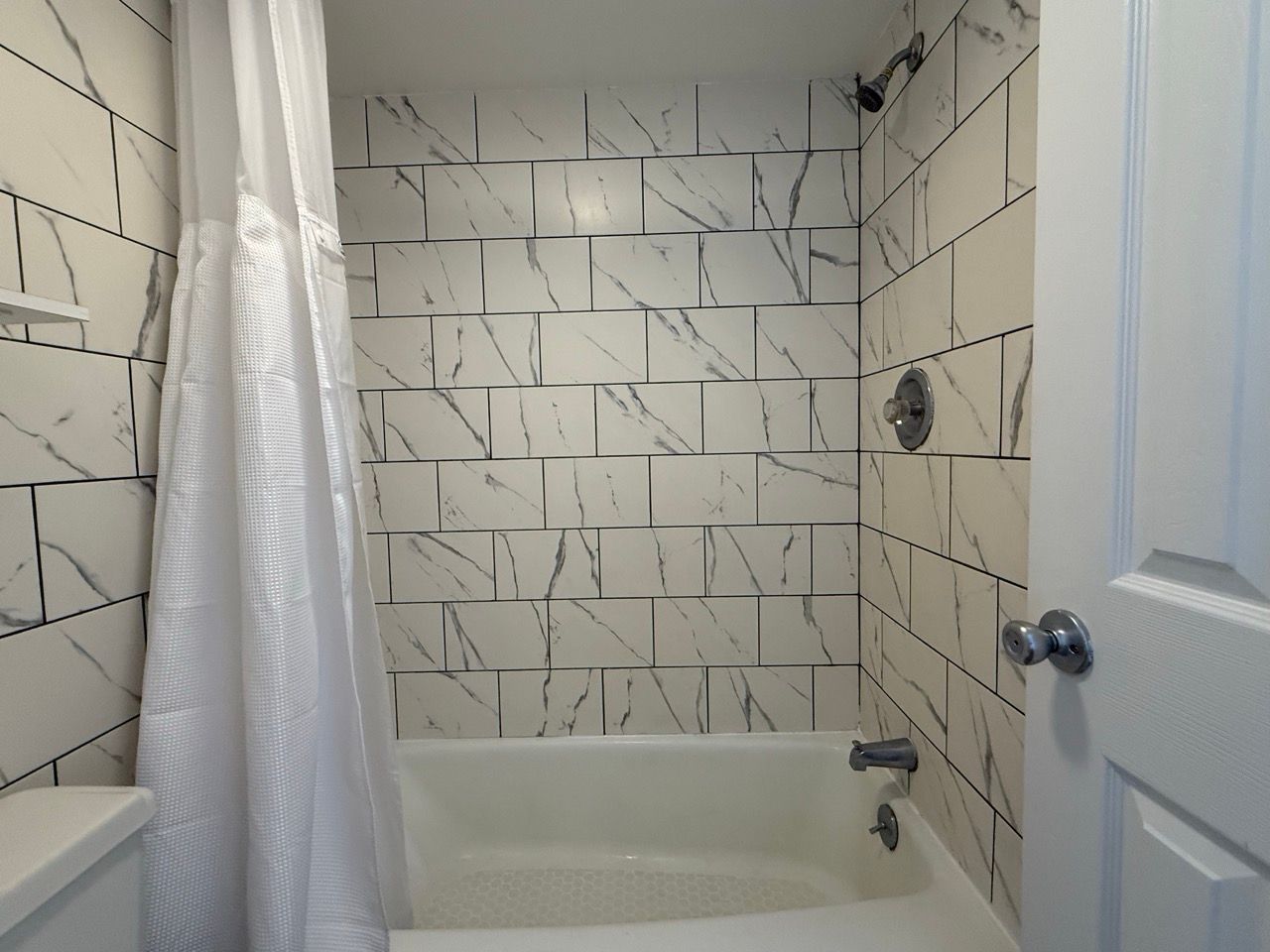 A bathroom with a bathtub and a shower curtain