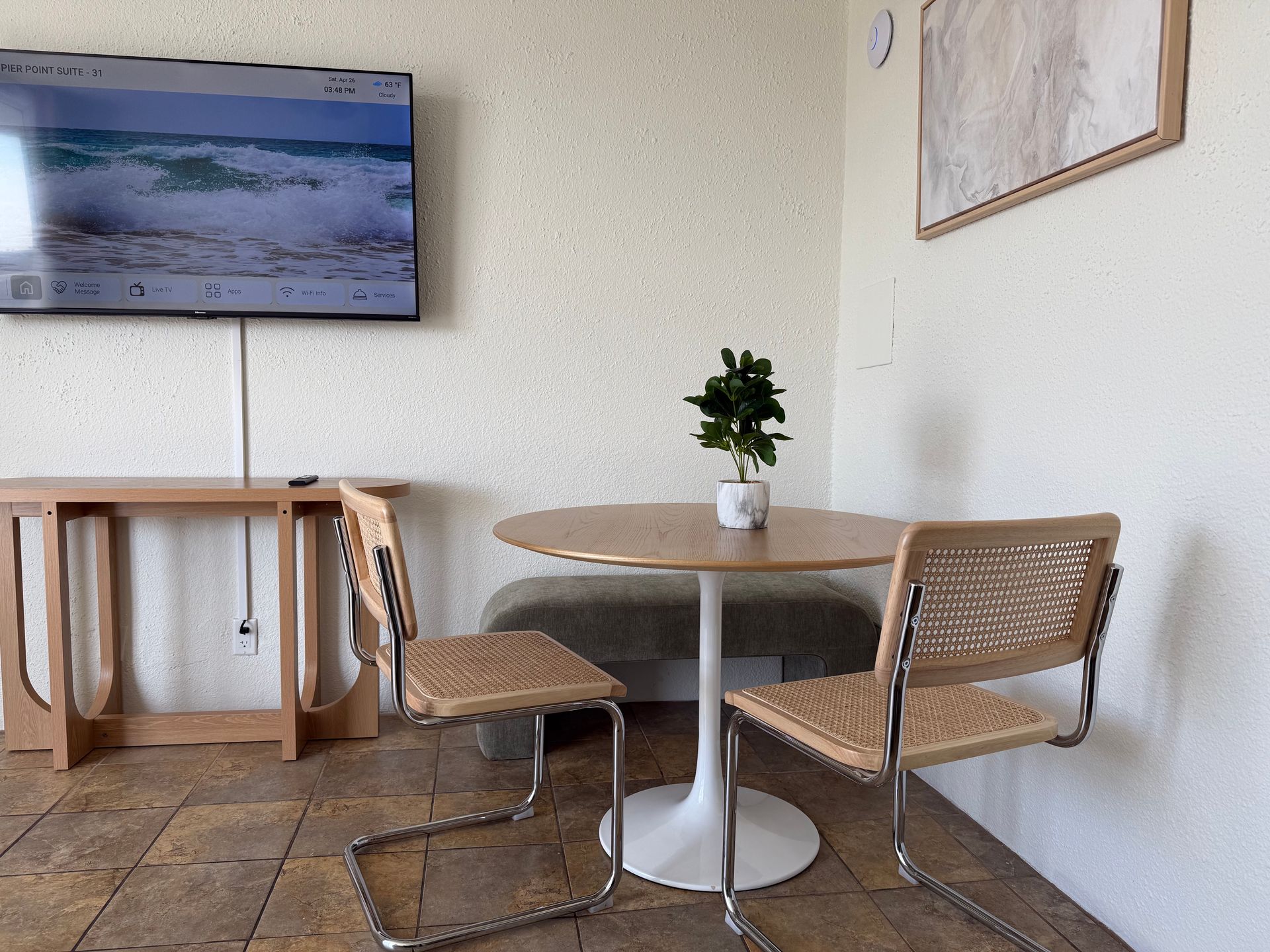 A room with a table and chairs and a flat screen tv