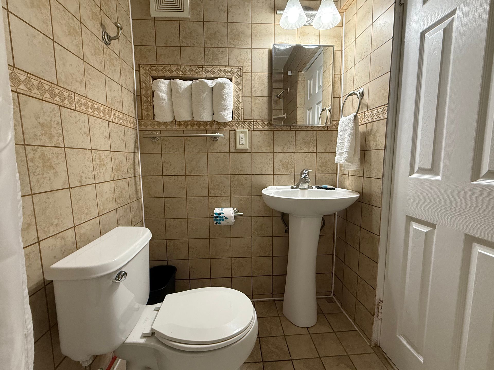 A bathroom with a toilet , sink and mirror