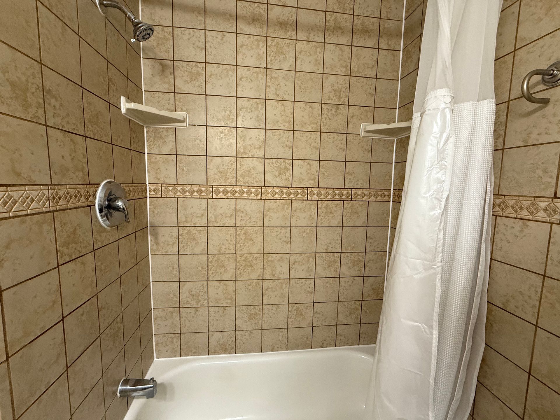A bathroom with a bathtub and a shower curtain