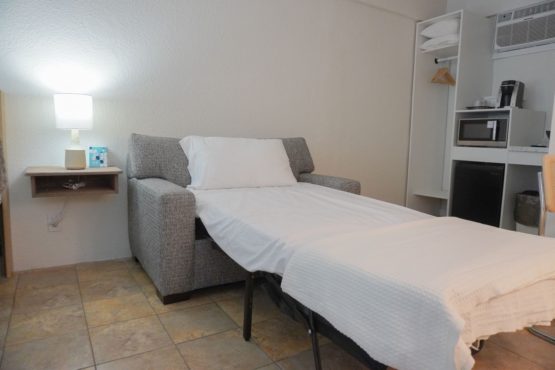 A hotel room with a couch that has been converted into a bed.
