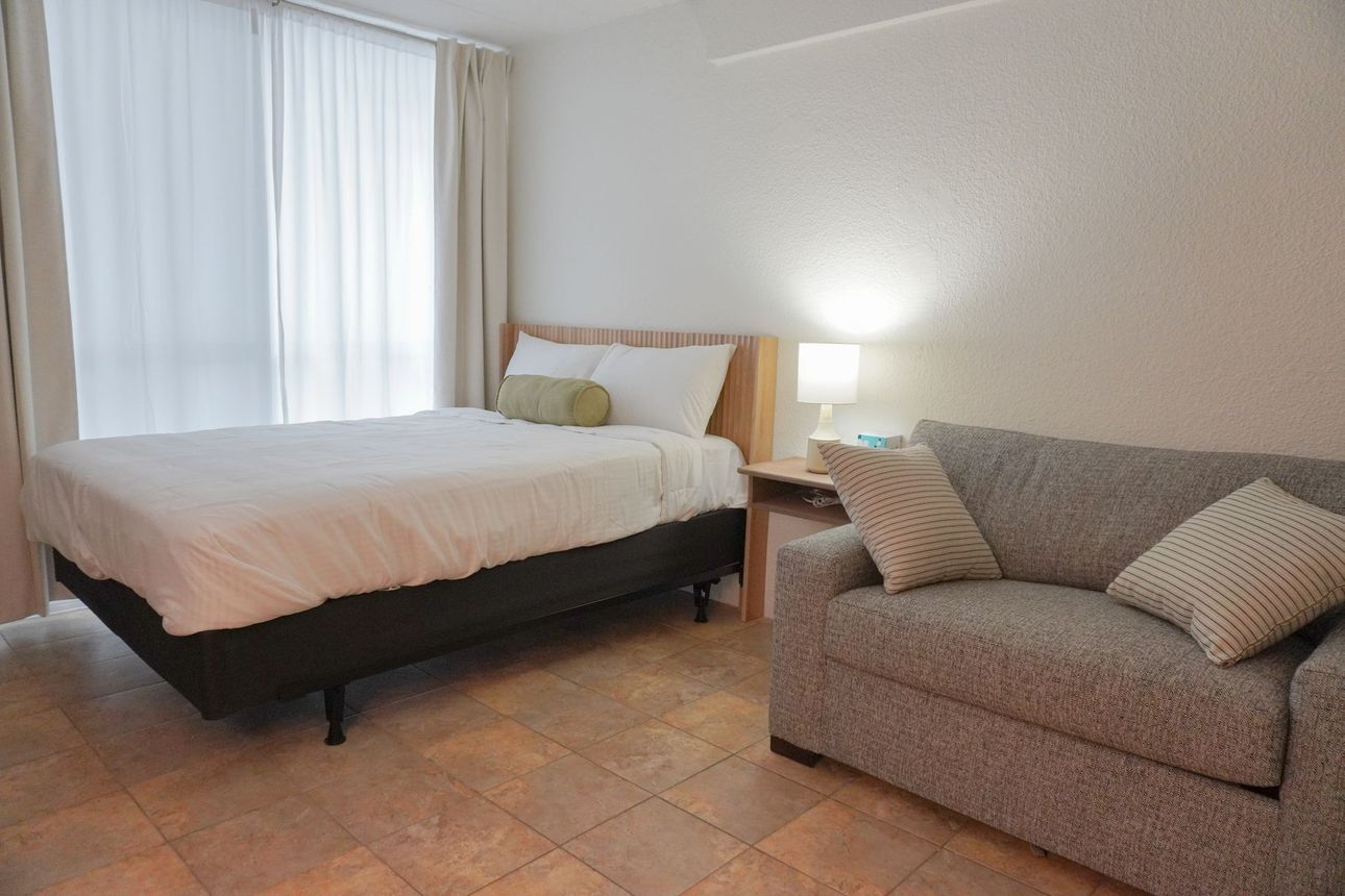 There is a bed and a couch in the room.