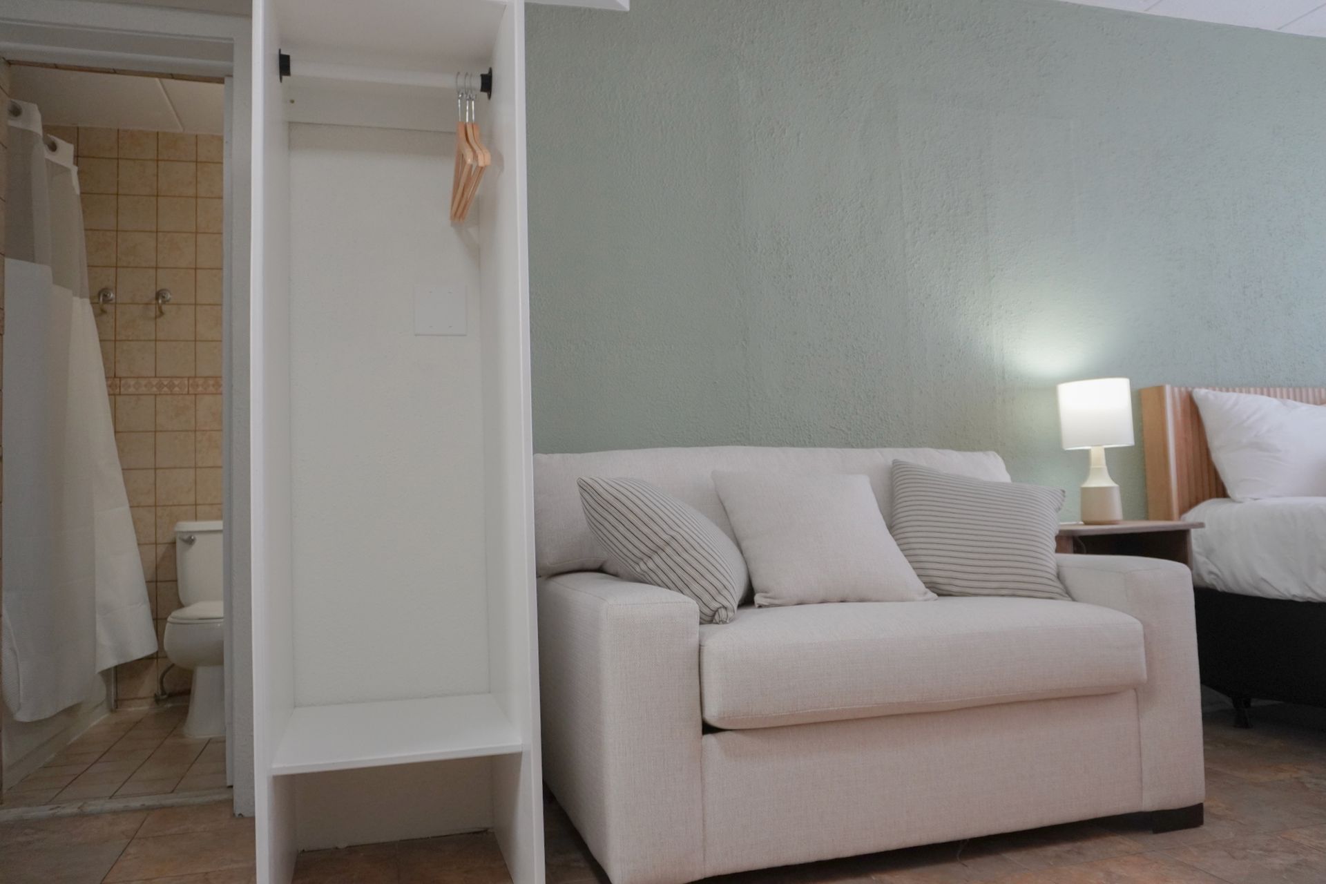 There is a couch and a bed in the room.