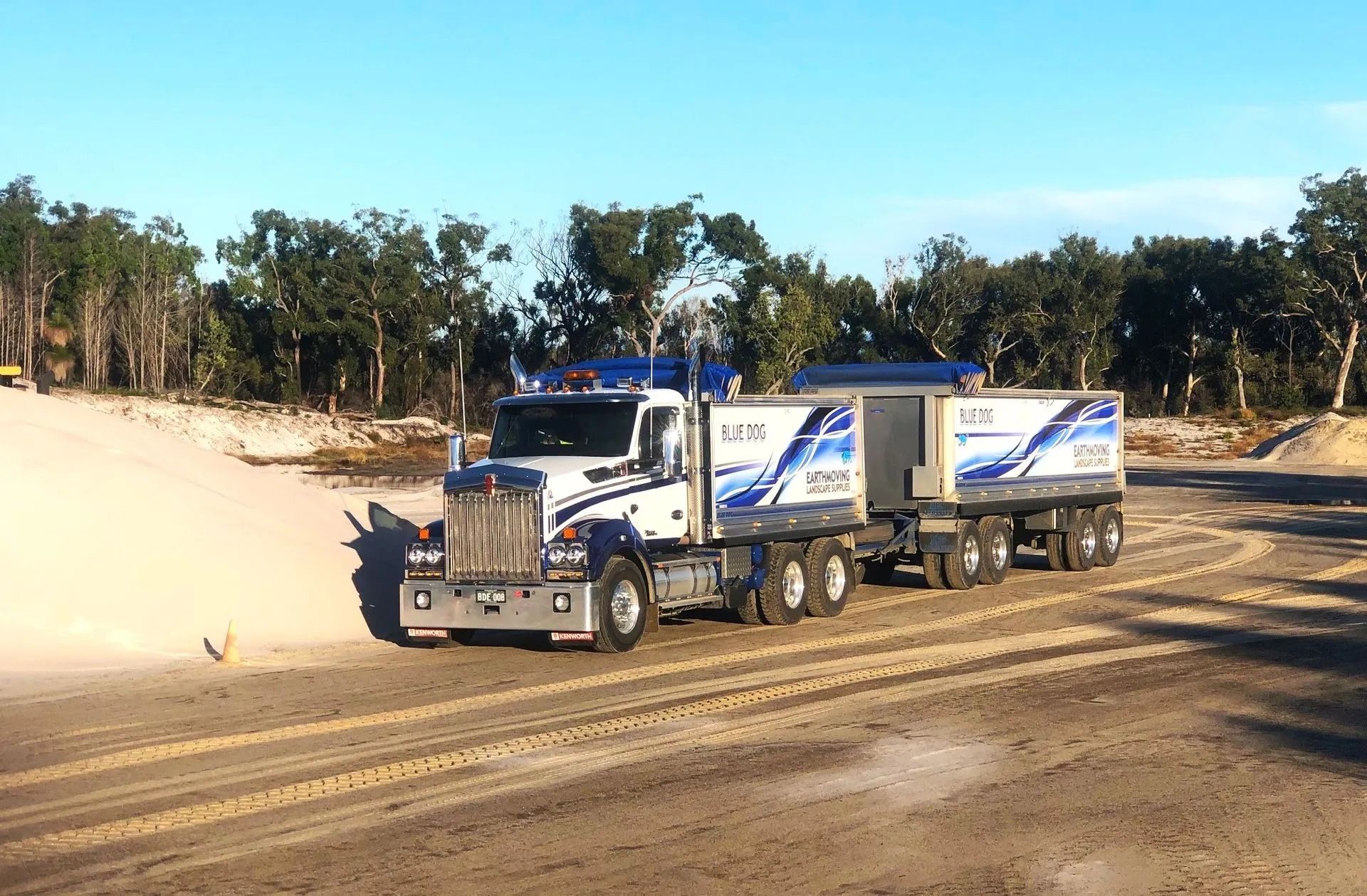 White and Blue Semi-truck on Dirt Road, Hauling Two Trailers — Blue Dog Earthmoving Landscape Supplies in Newee Creek, NSW