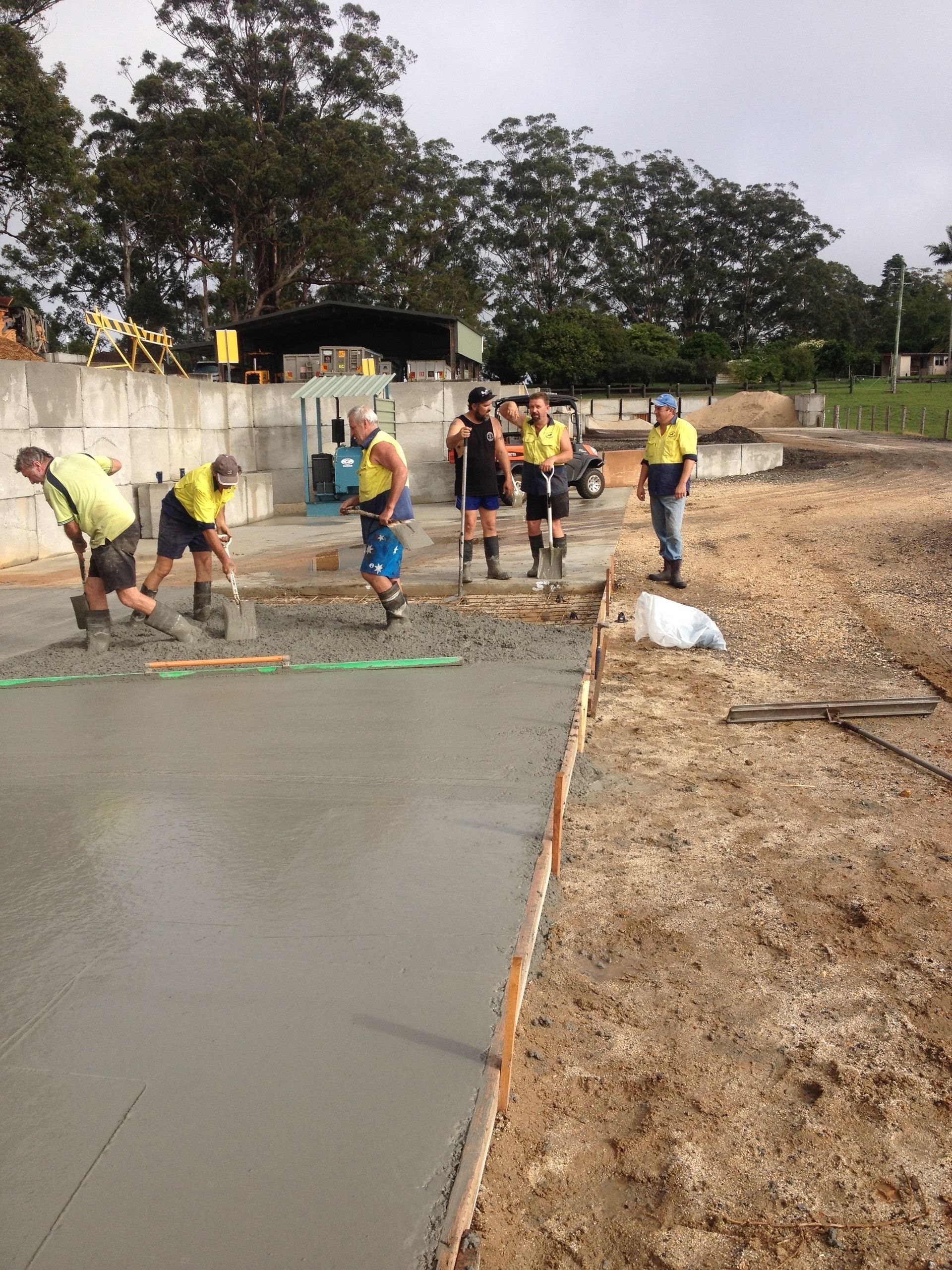 Workers Smoothing Concrete on a Construction Site — Blue Dog Earthmoving Landscape Supplies in Newee Creek, NSW