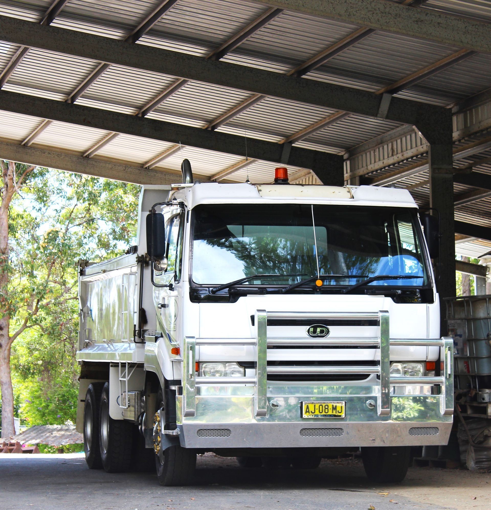White Dump Truck Parked Under a Metal Roof — Blue Dog Earthmoving Landscape Supplies in Newee Creek, NSW
