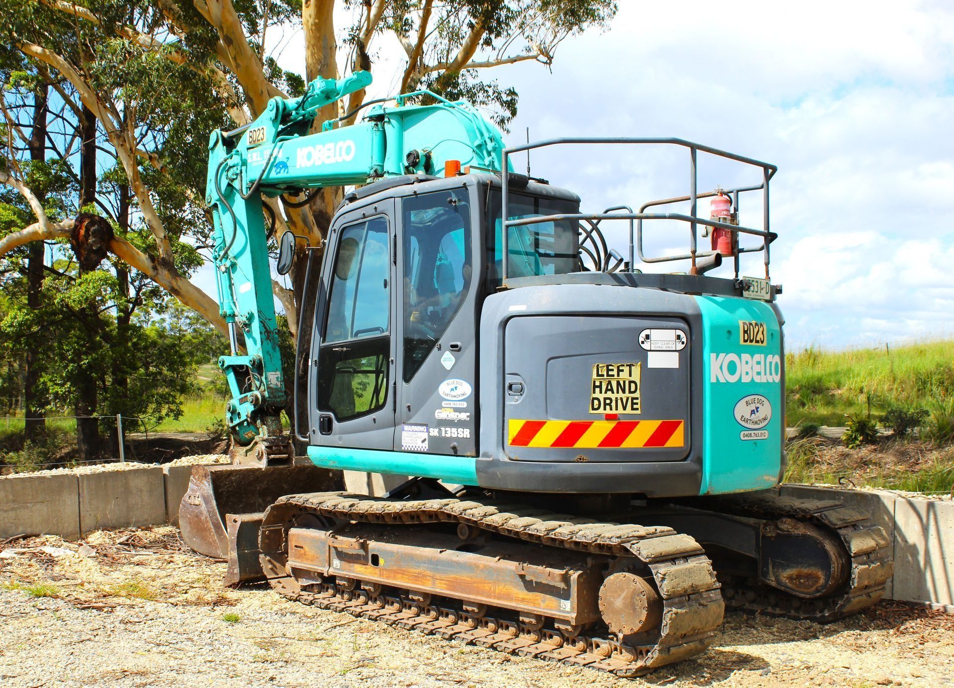 A Teal and Gray Kobelco Excavator Parked on a Gravel Surface — Blue Dog Earthmoving Landscape Supplies in Newee Creek, NSW