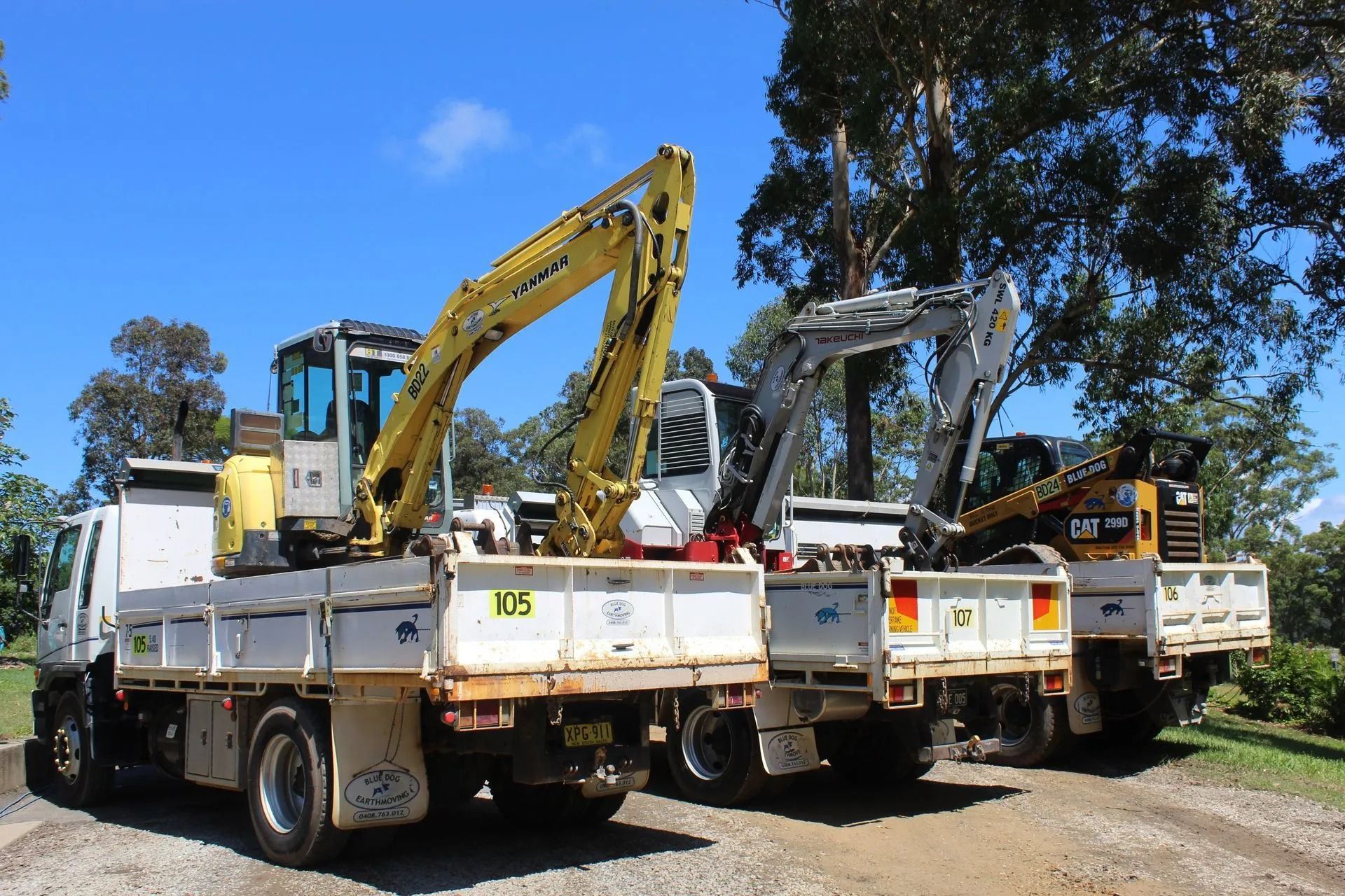 Three Backhoe Loaders on Flatbed Trucks Parked Outdoors — Blue Dog Earthmoving Landscape Supplies in Newee Creek, NSW