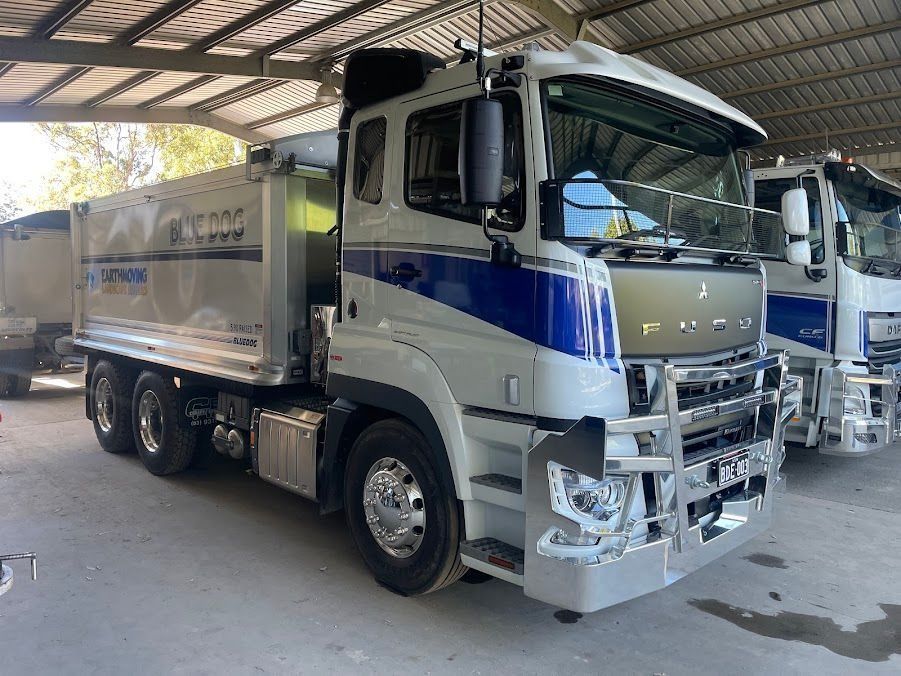 Gray and Blue Dump Truck Parked Under a Covered Structure — Blue Dog Earthmoving Landscape Supplies in Newee Creek, NSW