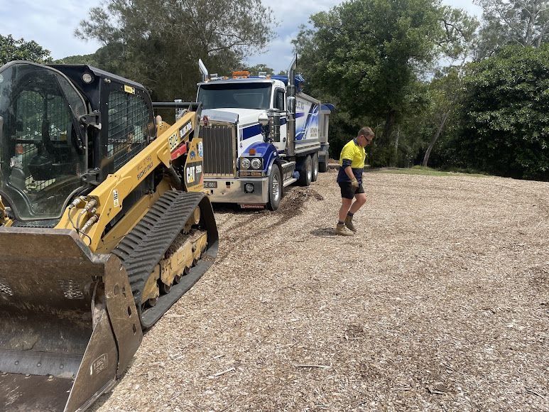 A Skid Steer and Dump Truck on a Gravel Lot — Blue Dog Earthmoving Landscape Supplies in Scotts Head, NSW