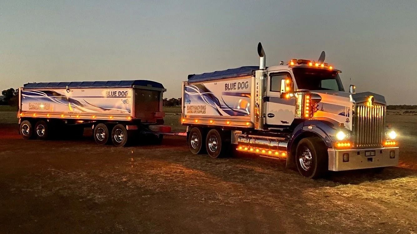 Blue and White Semi-truck and Trailer on a Field at Dusk — Blue Dog Earthmoving Landscape Supplies in Newee Creek, NSW