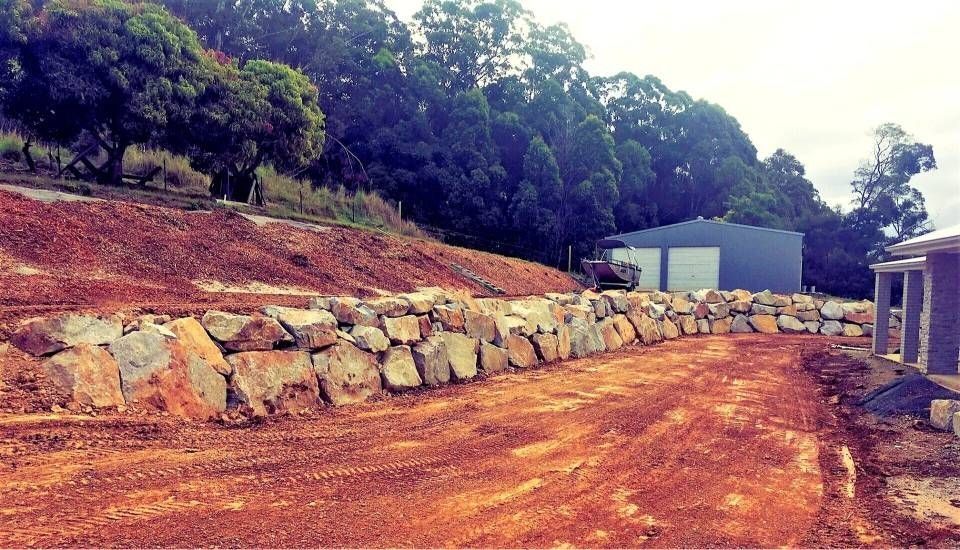 A Dirt Road With a Rock Retaining Wall, a Metal Shed — Blue Dog Earthmoving Landscape Supplies in Newee Creek, NSW