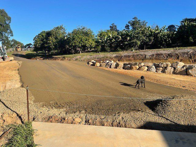 Dirt Road Under Construction With a Dog Walking on It — Blue Dog Earthmoving Landscape Supplies in Urunga, NSW