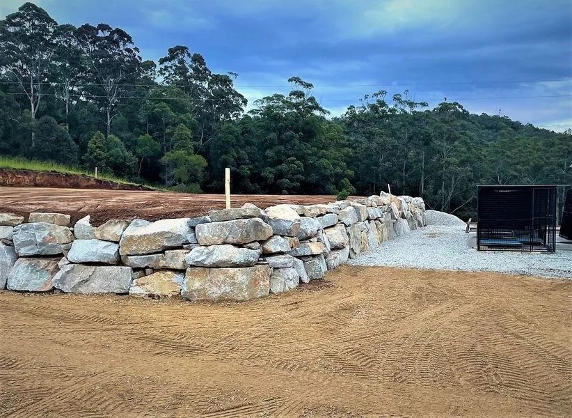 Stone Retaining Wall With a Gravel Driveway — Blue Dog Earthmoving Landscape Supplies in Newee Creek, NSW
