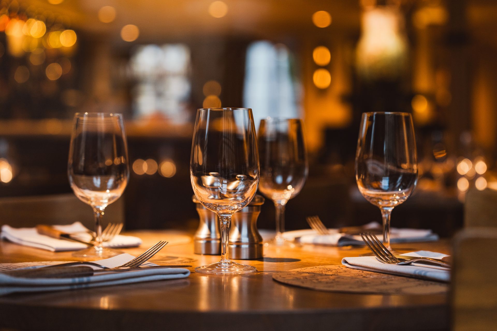 Un tavolo apparecchiato per una cena con bicchieri da vino e posate.