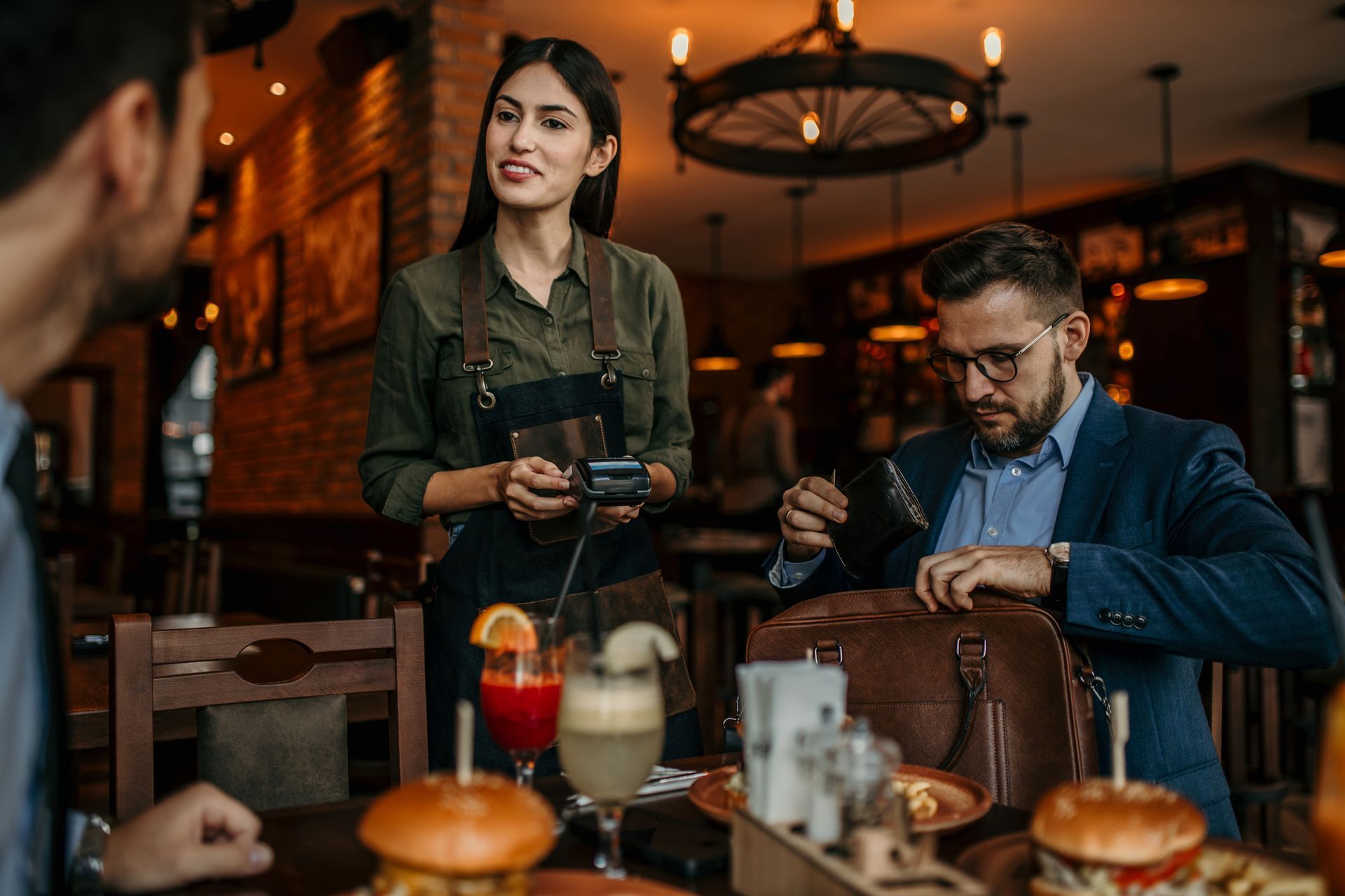 Una cameriera serve un uomo e una donna in un ristorante.
