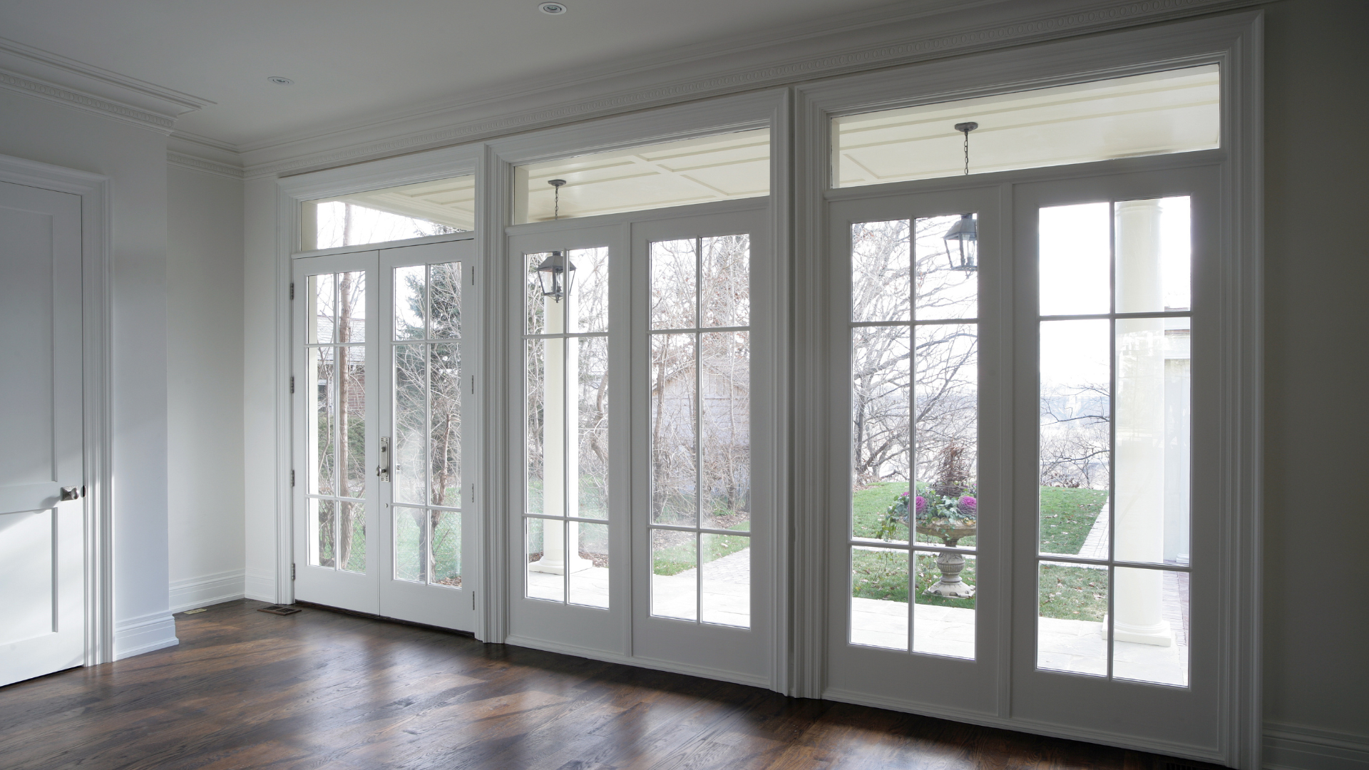 An empty room with a lot of windows and doors.