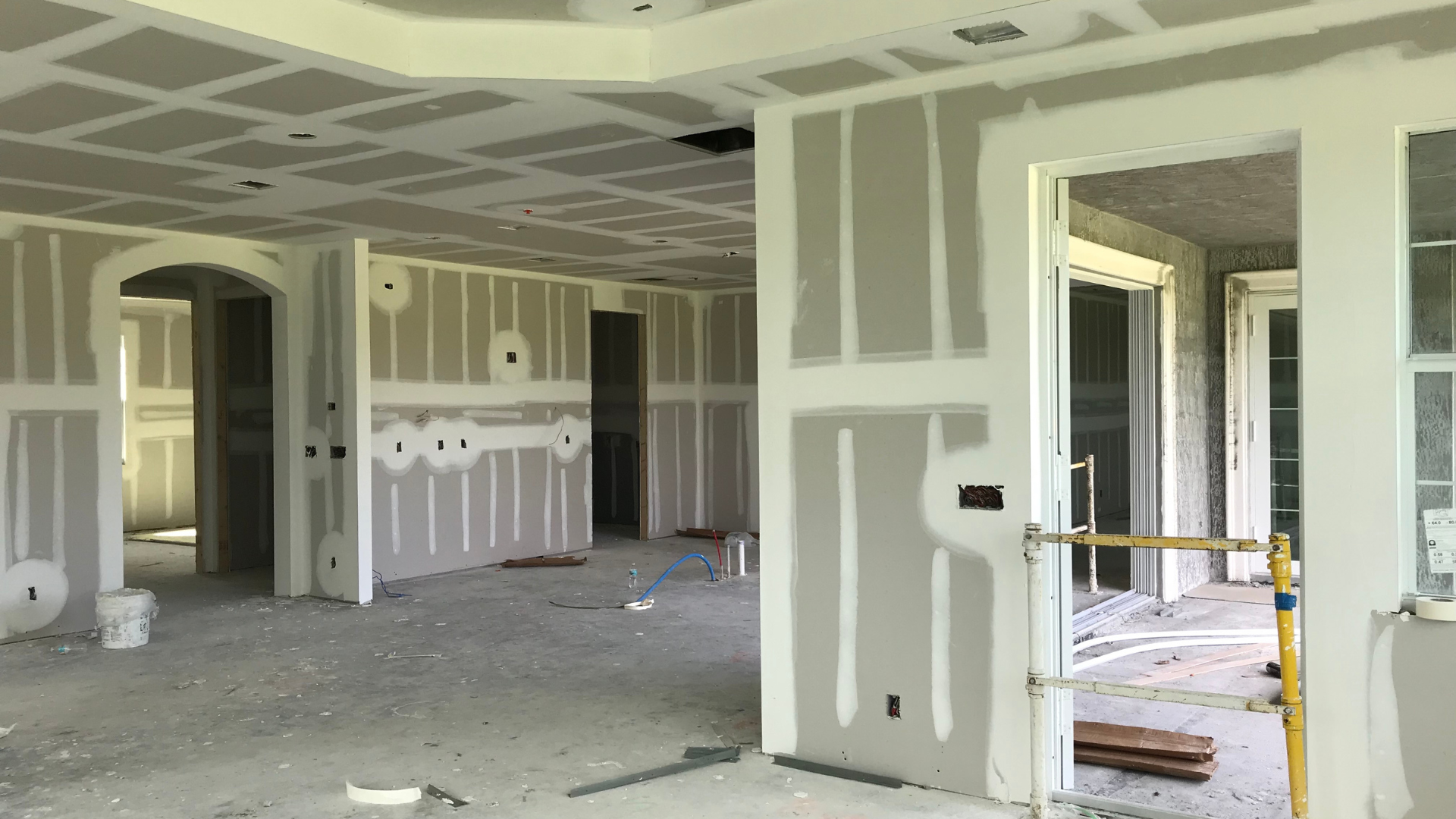 A large empty room with drywall on the walls and doors.