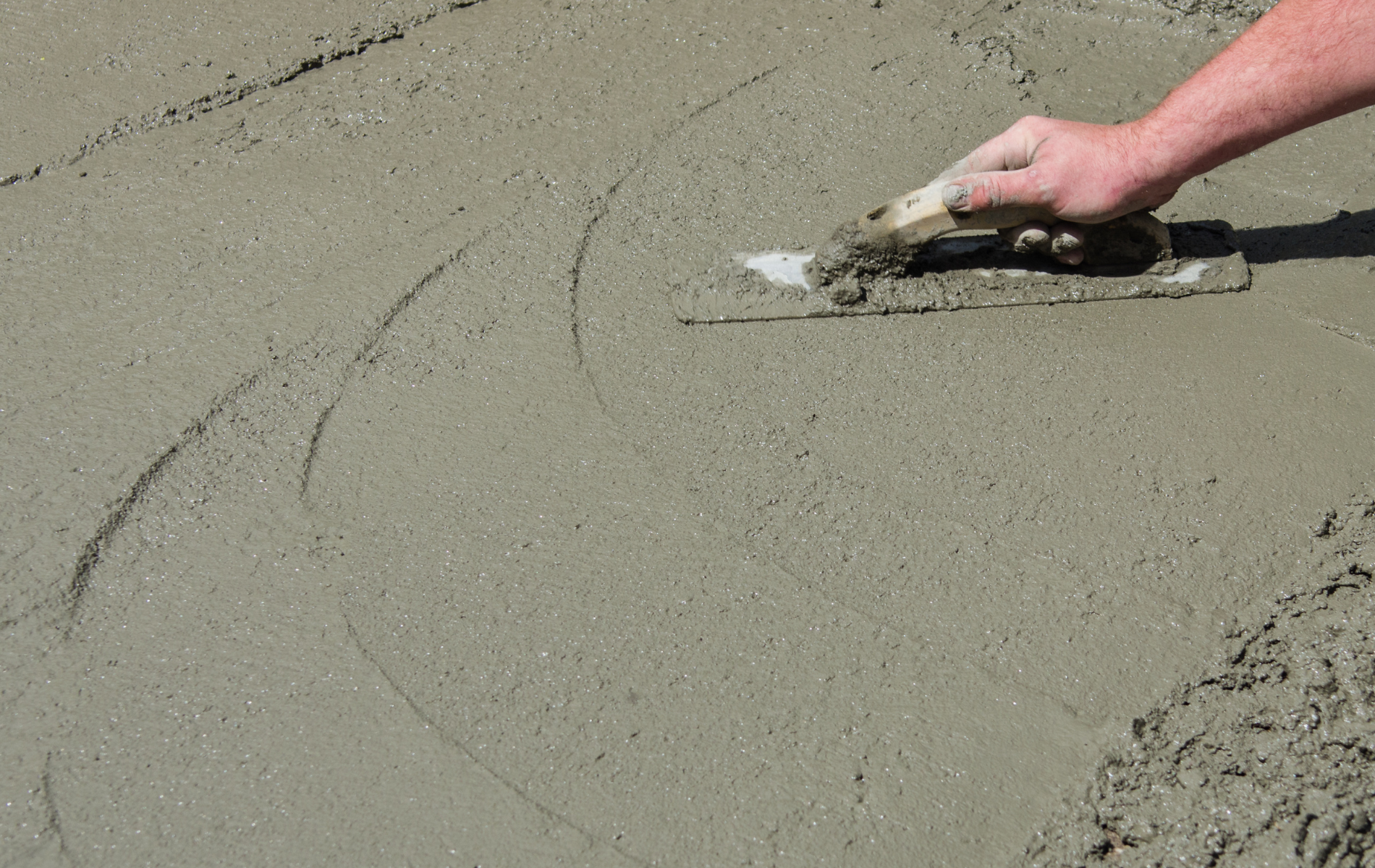 A person is pouring concrete with a hose.