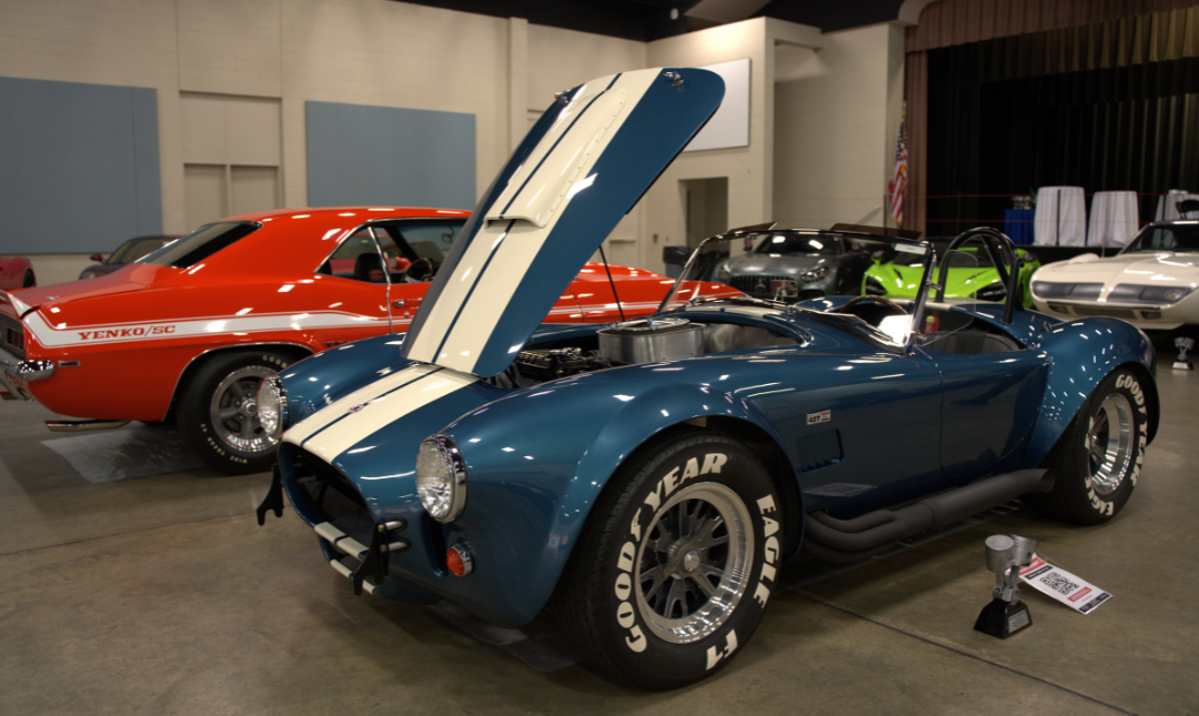 Classic roadster at car show with hood raised