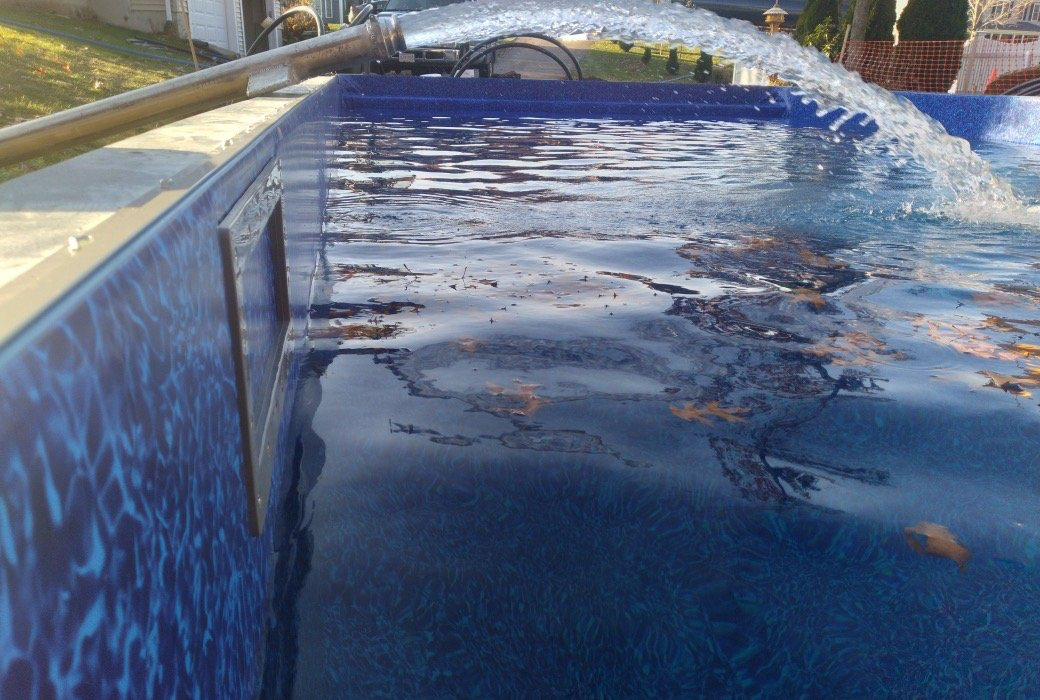 Photo of an in-ground pool getting refilled.
