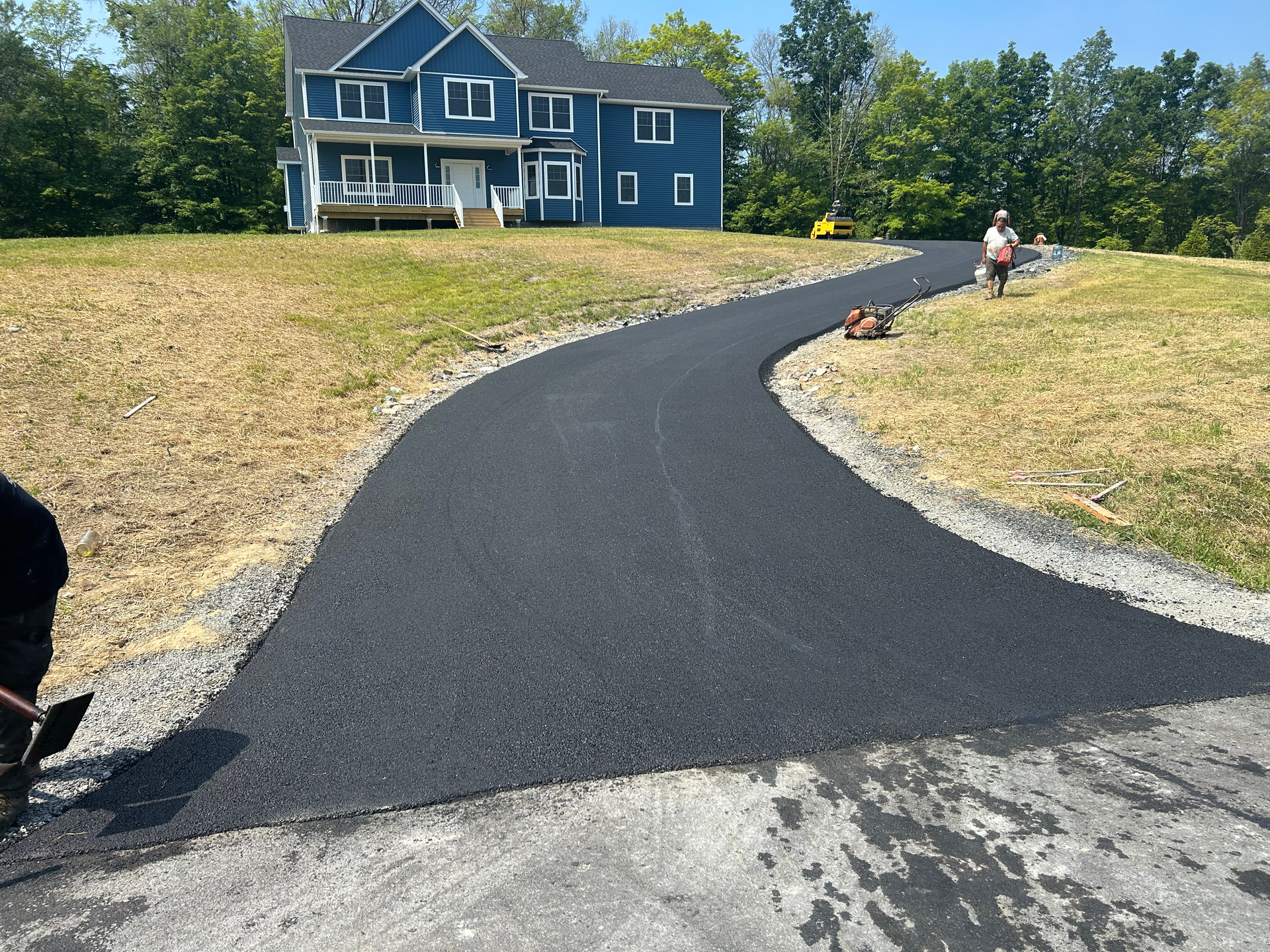 Yellow police tape blocks a gravel driveway leading to two houses