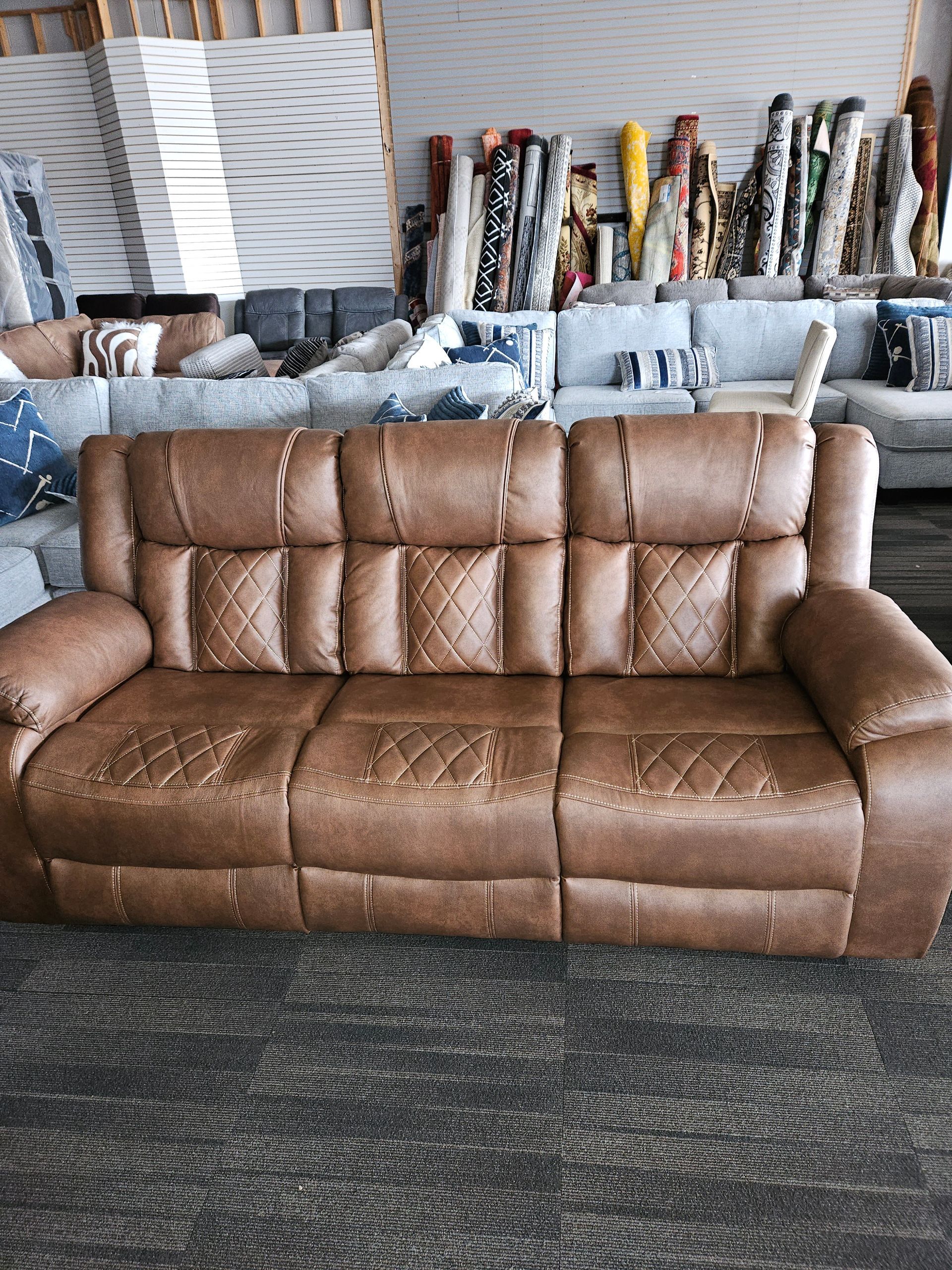 Brown leather reclining sofa in a furniture store.