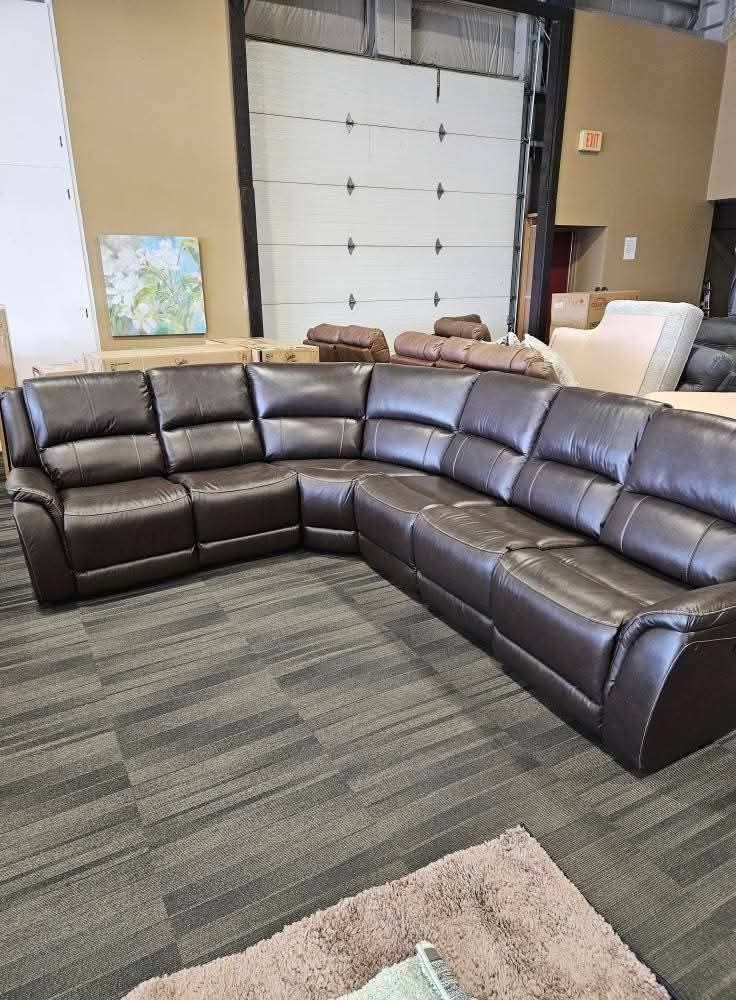 Brown leather sectional sofa in showroom setting.