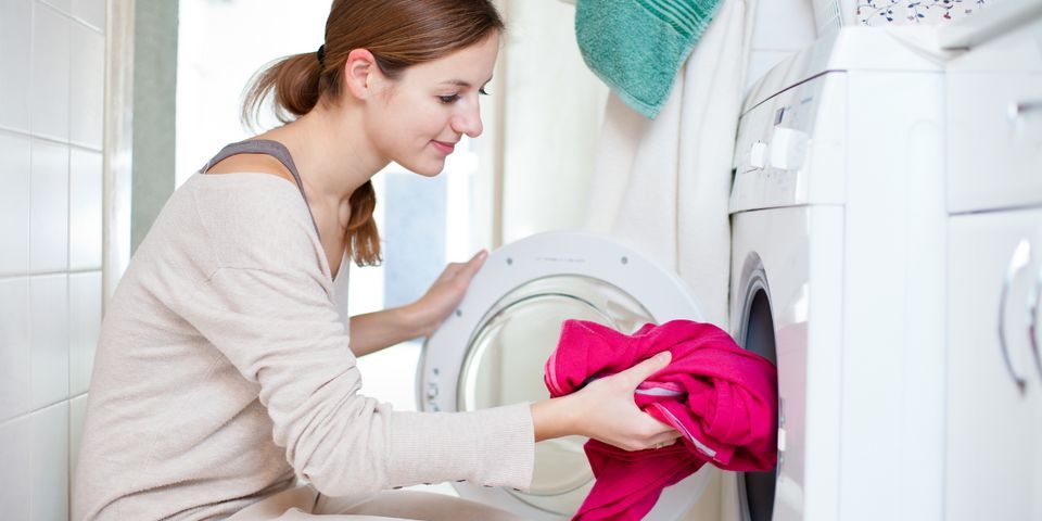 Woman Putting Clothes in Washing Machine — Elyria, OH — Expert Appliance Solutions Woman Putting Clothes in Washing Machine — Elyria, OH — Expert Appliance Solutions