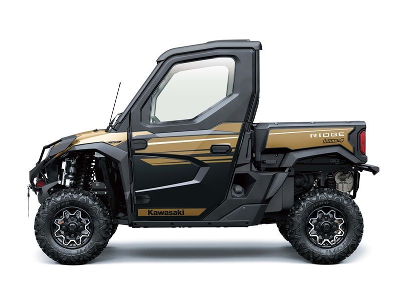 Side view of a black and gold Kawasaki Ridge, an off-road utility vehicle with a covered cab and a cargo bed.