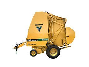 Yellow Vermeer 504R round hay baler machine on wheels, outdoors.