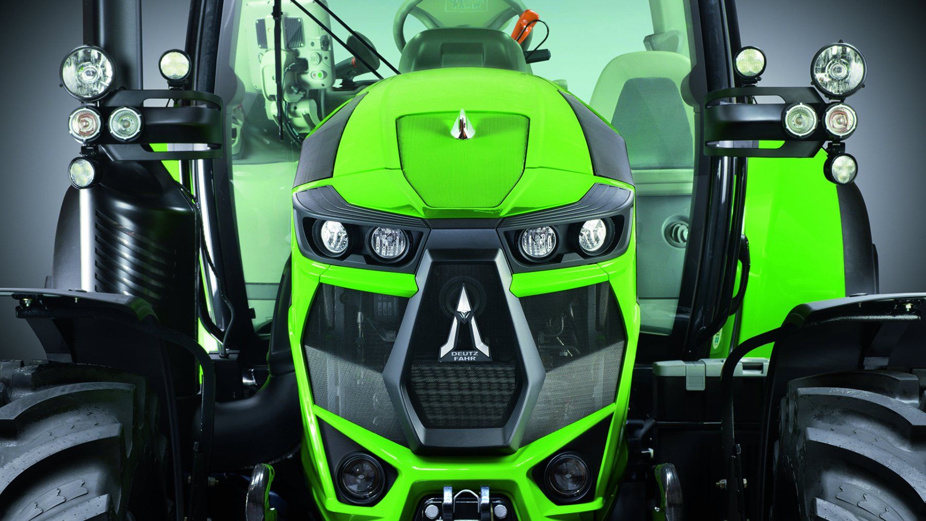 Green and black Deutz-Fahr tractor, front view, with headlights and a stylized grill.