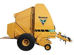 Yellow Vermeer 604R hay baler, agricultural equipment, on wheels.