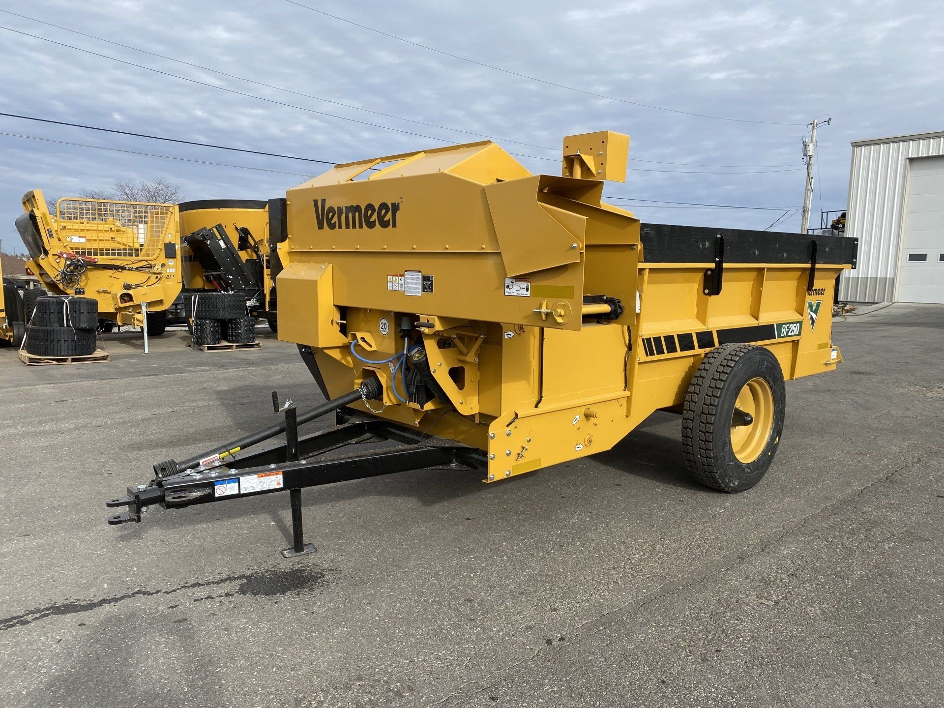 Yellow Vermeer stump grinder on a trailer, parked on asphalt.