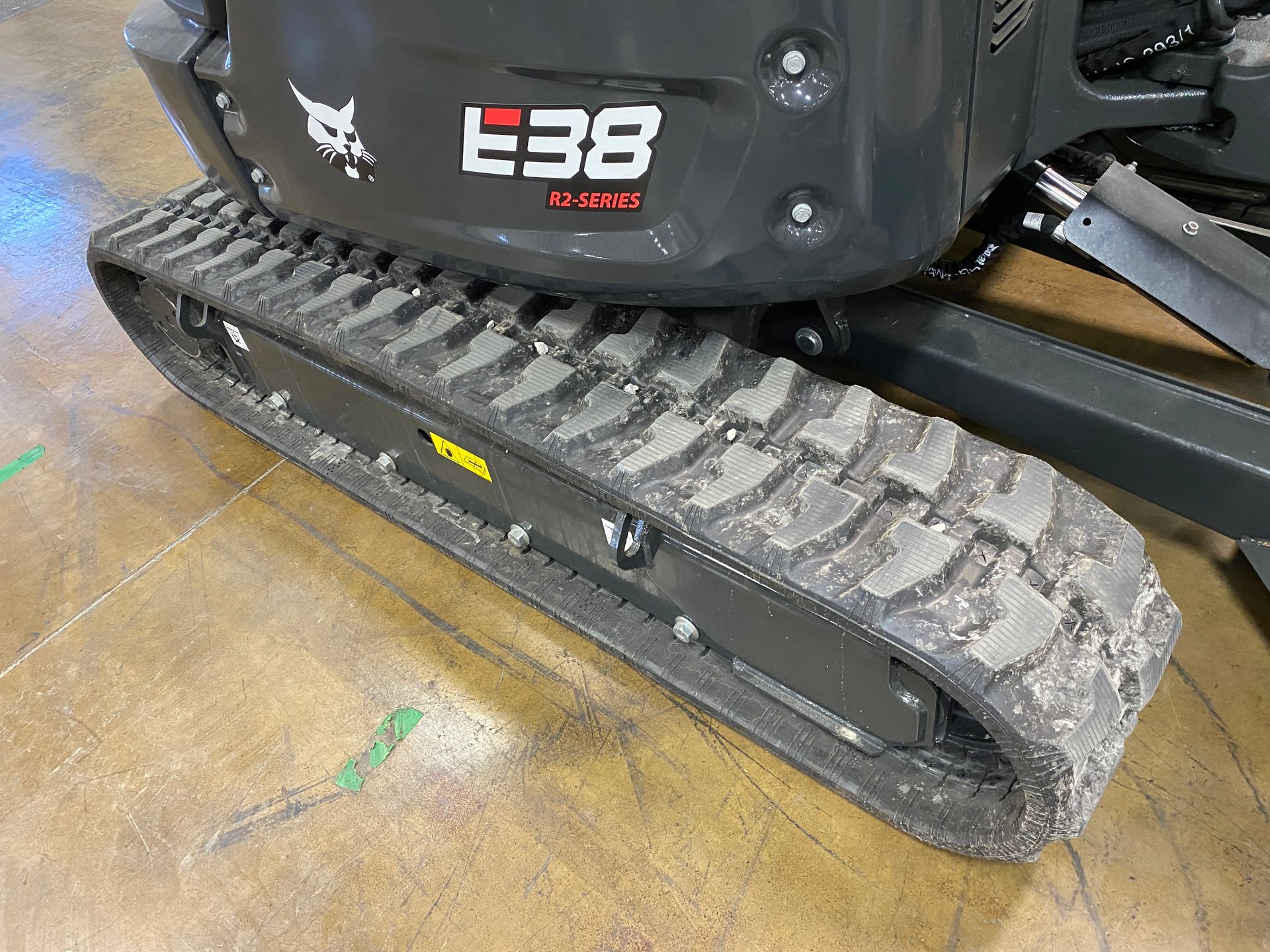 Close-up of a Bobcat E38 mini excavator track, with grey rubber track and machine body.