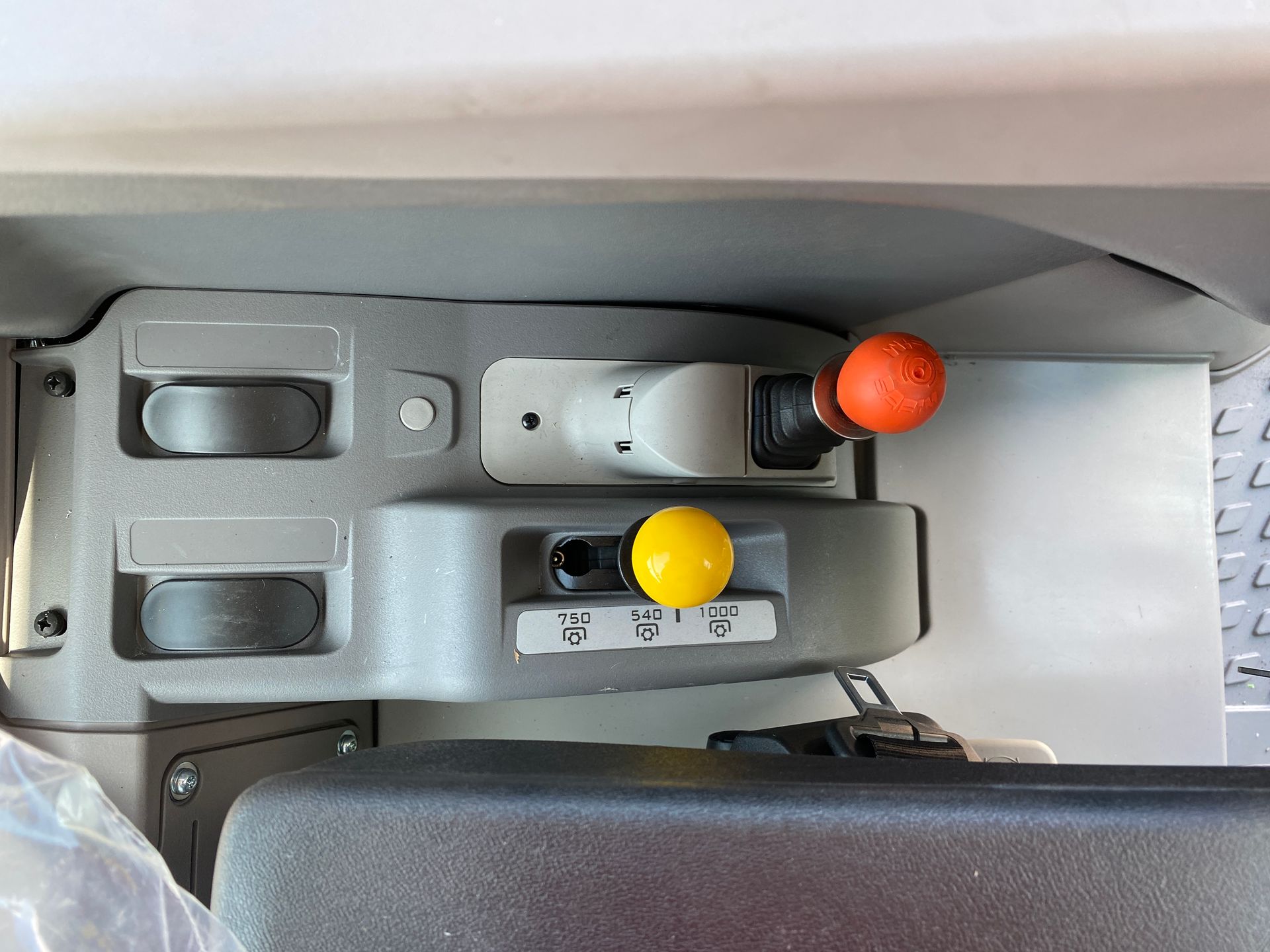 Control panel with orange and yellow knobs, levers, and buttons.