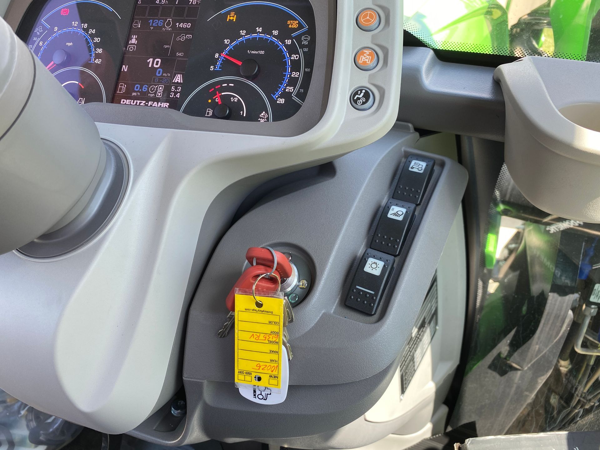 Dashboard of a tractor, showing gauges, keys, and control switches.