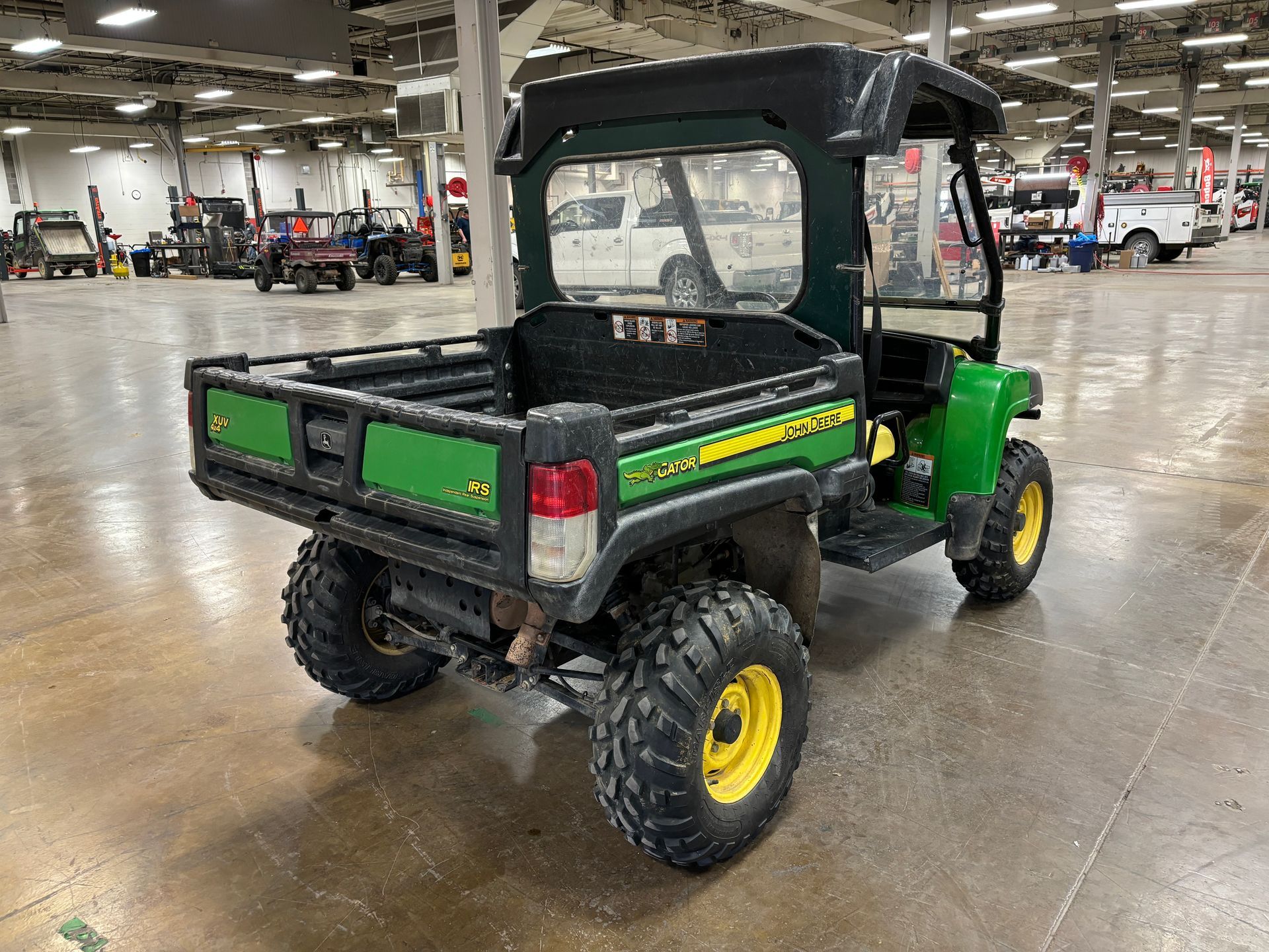 Green and yellow John Deere Gator utility vehicle.