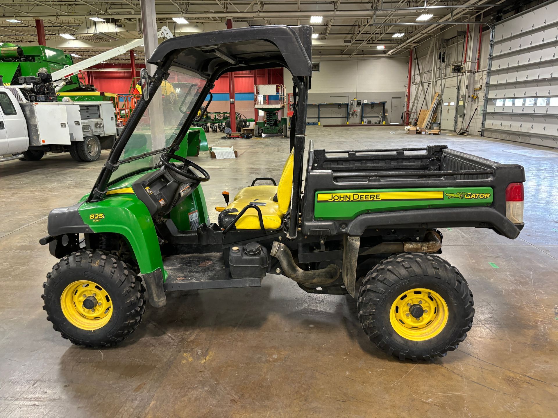 Green and yellow John Deere Gator utility vehicle.