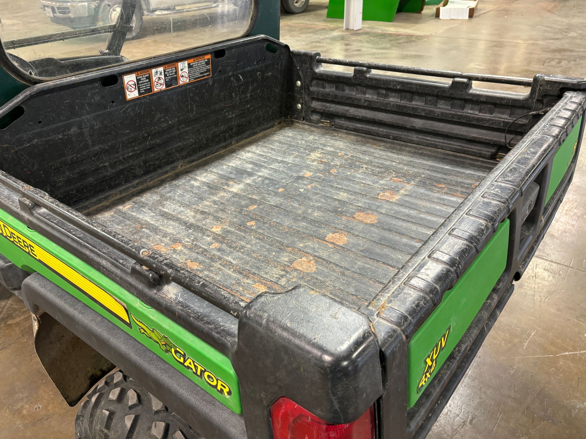 Green and black John Deere Gator utility vehicle bed.