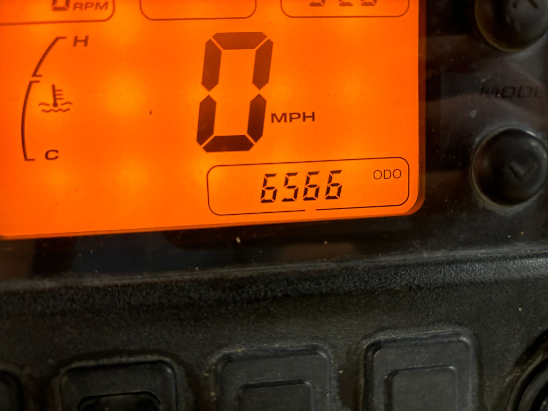 Orange digital display shows 0 MPH, engine temperature, and 6566 odometer reading.