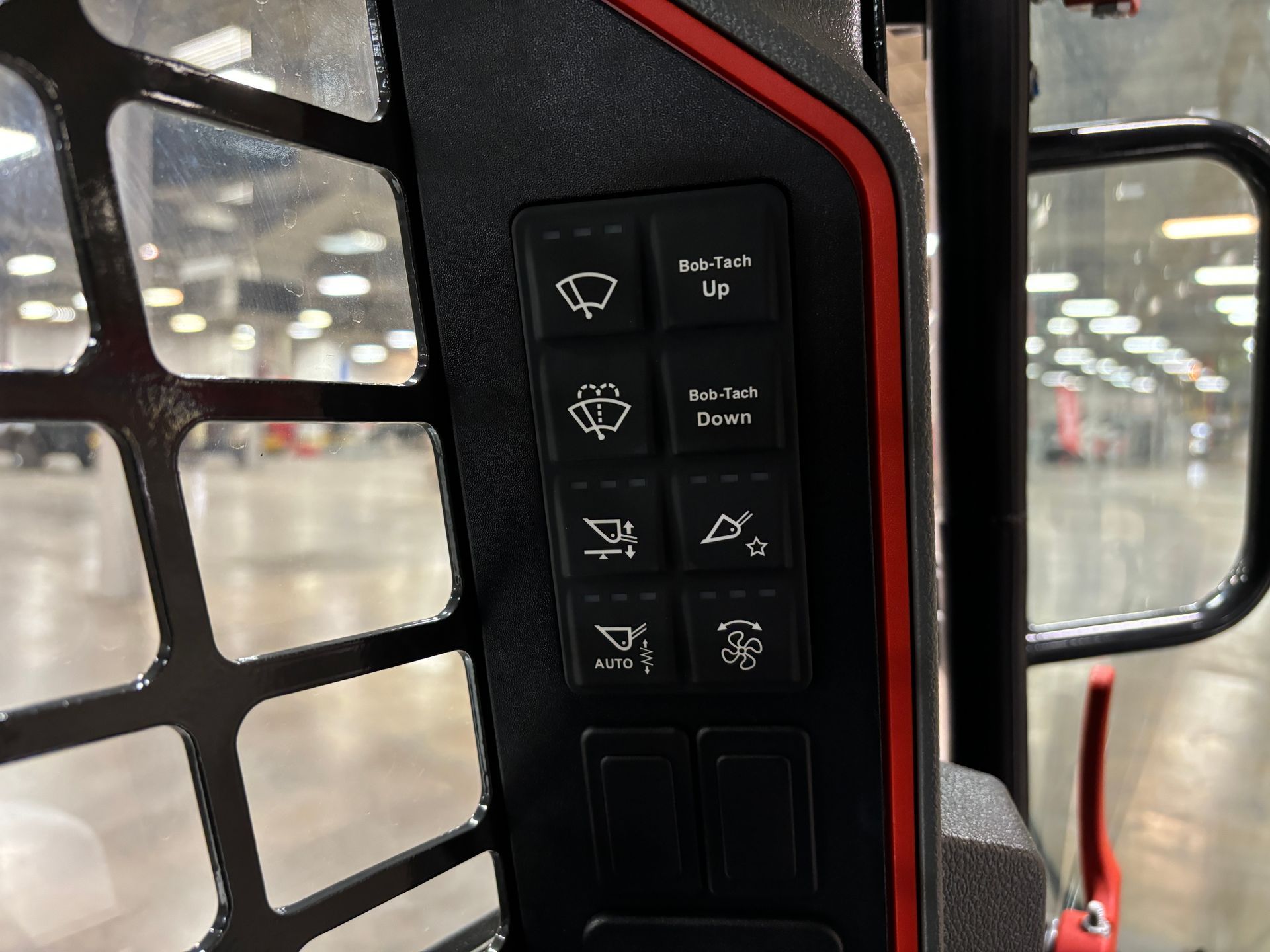 Black control panel with illuminated icons for a skid steer loader.