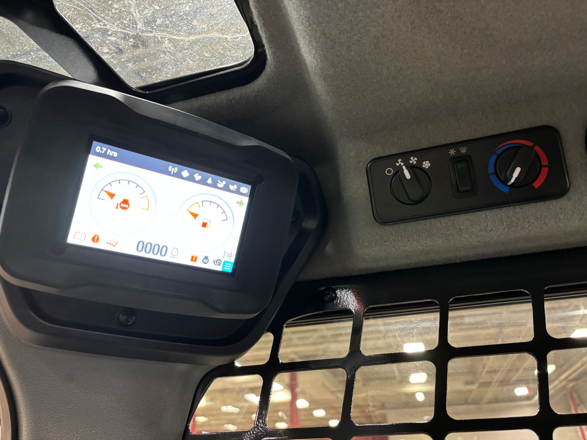 Dashboard with digital display and climate controls in a cab.